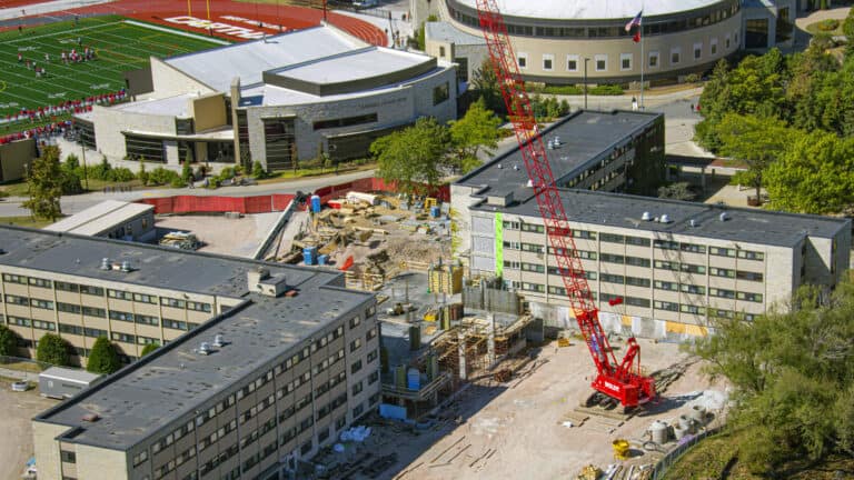  crane working on an educational campus between buildings
